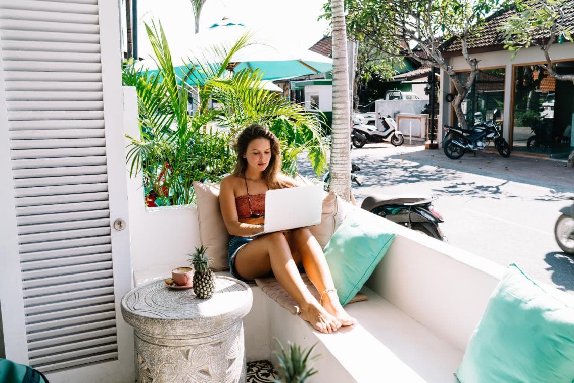 A destination-based travel professional working from a sunny terrace